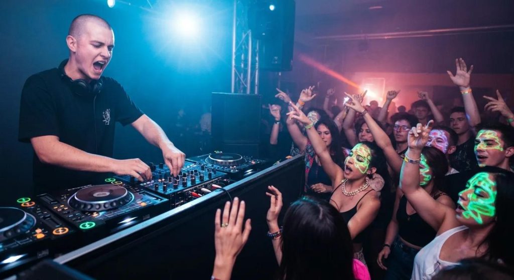 DJ mixing at a lively event with colorful lights and an engaged crowd