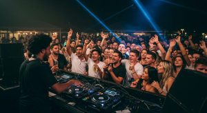 DJ performing at a lively celebration on the Central Coast with colorful lighting and dancing crowd