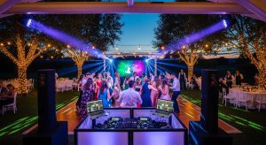 Wedding DJ setup at an outdoor venue with guests dancing and vibrant lighting